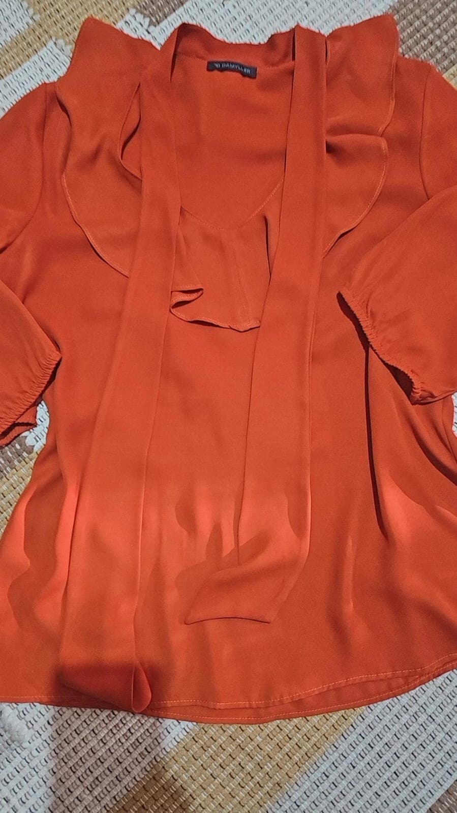 Bata laranja terracota de tecido fluido, com tiras de gravata soltas no decote, babado frontal e manga com punho elástico