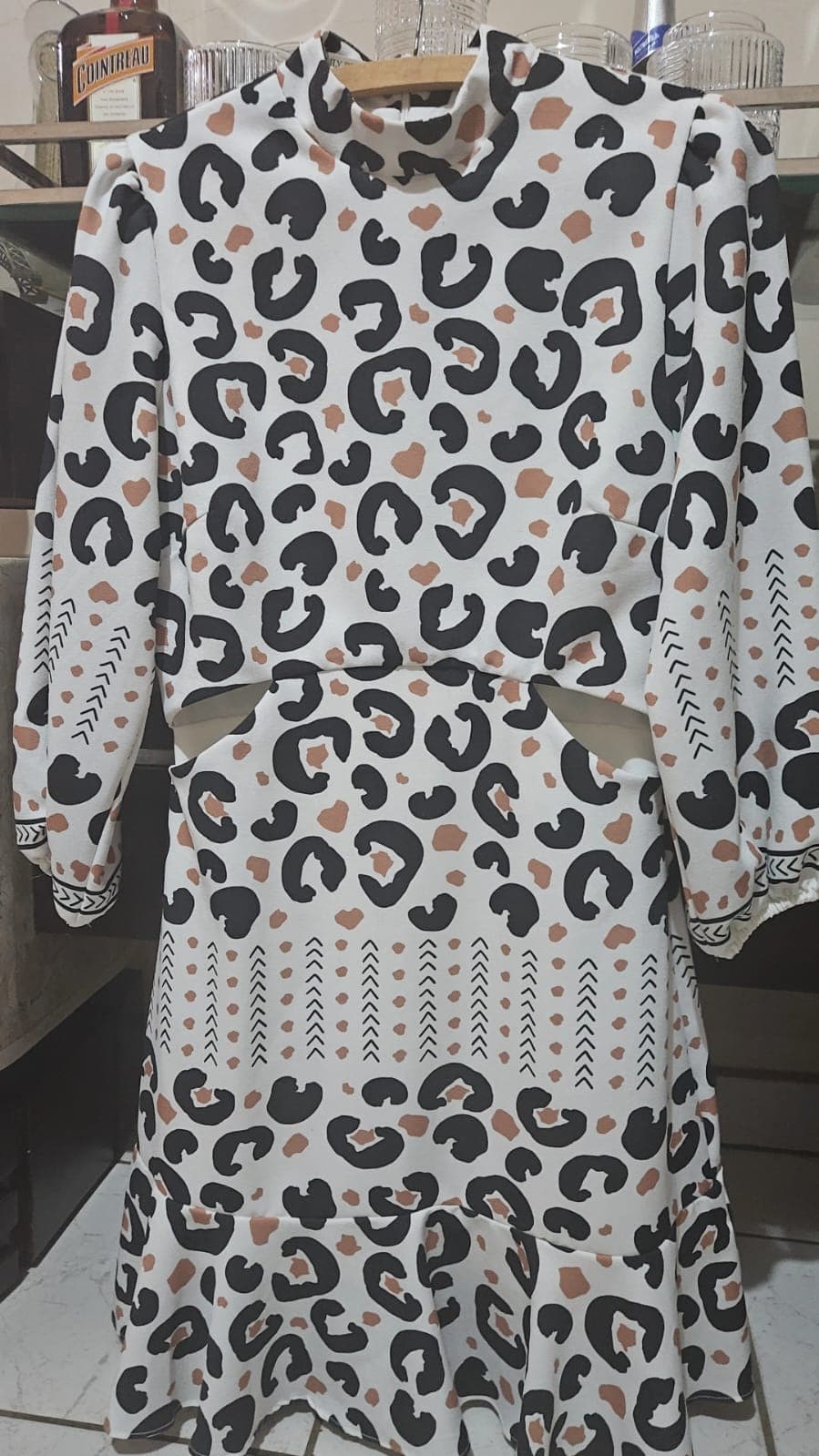 Vestido branco de estampa animal print em preto e terracota, gola alta, manga longa e recortes vazados na cintura