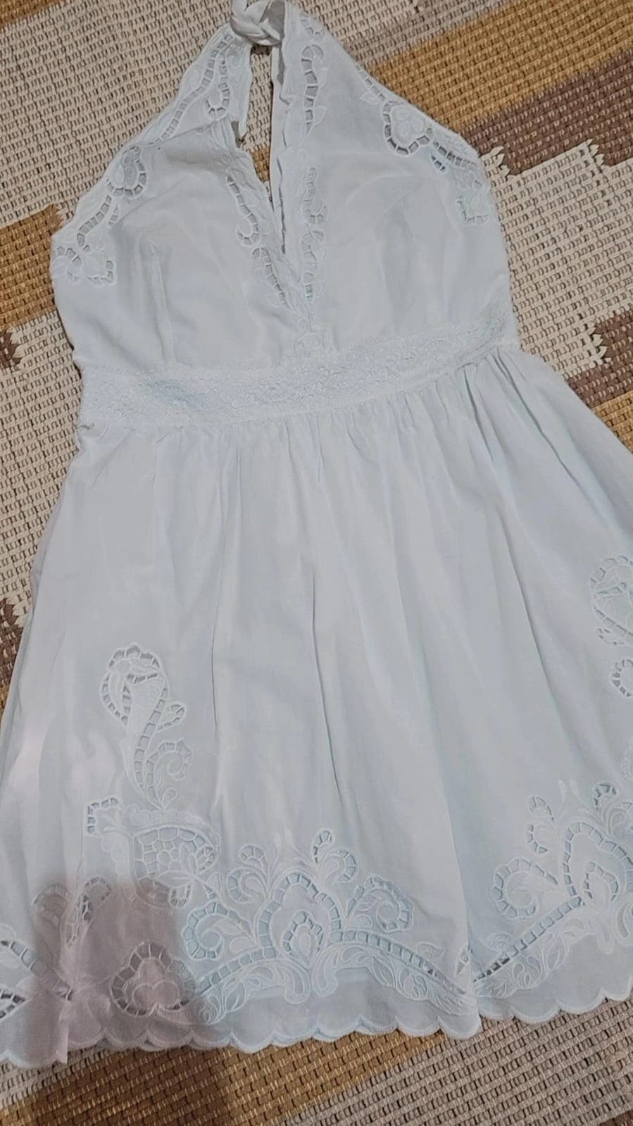 Vestido curto branco frente única, com amarração no pescoço, bordado richelieu no busto e na barra e acabamento escalopado